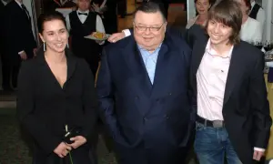 Wojciech Mann z córką i synem. Uśmiechnięci pozują do zdjęcia w eleganckich strojach.