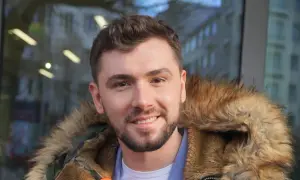 Uśmiechnięty Kamil Bednarek w futrzanej kurtce. Może właśnie wraca do swojej żony po koncercie.