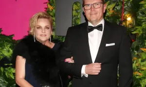 Marcin Bosacki i jego partnerka na ściance. Elegancka para, ona w futrze i biżuterii, on w smokingu.