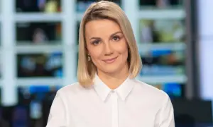 Joanna Dunikowska-Paź, znana z Wikipedii, w białej koszuli, z kolczykami, na tle ekranów.