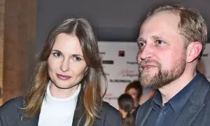 Piotr Adamczyk z żoną, uśmiechnięci, pozują do zdjęcia.