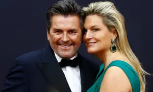 Thomas Anders z żoną z Polski, piękną blondynką w szmaragdowej sukni i efektownych kolczykach, uśmiechają się do obiektywu.