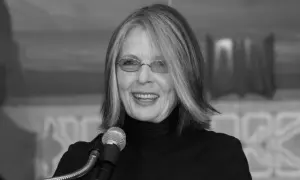 Diane Keaton w okularach i czarnym golfie, uśmiechnięta przy mikrofonie. Jej życie prywatne jest inspiracją dla wielu.