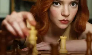 Anya Taylor-Joy jako Beth Harmon w "Gambicie Królowej" przygotowuje ruch na szachownicy.