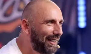 Radosław Bielecki, uśmiechnięty, z zarostem, w białej koszulce. Mimo choroby, widać w nim siłę i determinację.