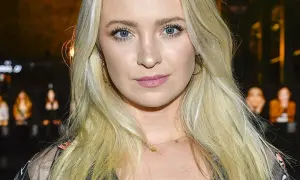 Blondynka z niebieskimi oczami, w złotych kolczykach, wygląda jakby była w centrum uwagi, może nawet w związku z jakąś aferą, jak kurdej szatan afera.