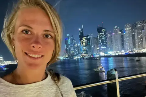 Magdalena Fręch prywatnie w Dubaju, nocą, z widokiem na rozświetlone wieżowce i wodę.