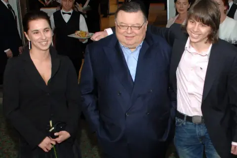 Wojciech Mann z córką i synem. Uśmiechnięci pozują do zdjęcia w eleganckich strojach.