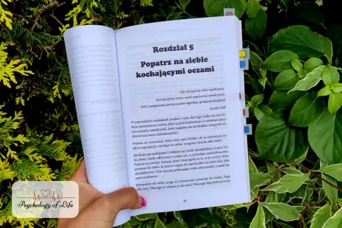 Otwarta książka z rozdziałem "Popatrz na siebie kochającymi oczami" zachęca do łagodnej, spokojnej akceptacji i samoakceptacji.