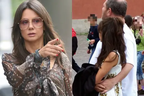 Kobieta w okularach i wzorzystej bluzce wskazuje palcem, obok mężczyzna obejmuje kobietę.