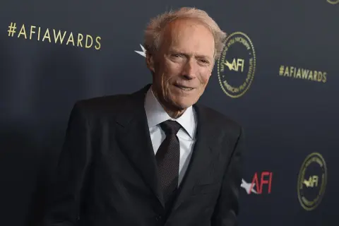 Clint Eastwood w garniturze na tle napisu #AFIawards.