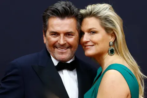 Thomas Anders z żoną z Polski, piękną blondynką w szmaragdowej sukni i efektownych kolczykach, uśmiechają się do obiektywu.