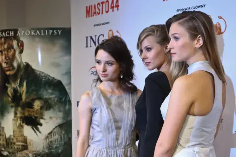 Trzy aktorki z obsady Miasto 44 na ściance. W tle plakat filmu i logo sponsorów.