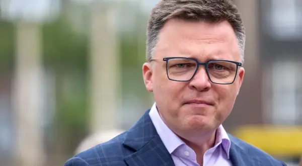 Szymon Hołownia w okularach, w garniturze. Mówi się o jego chorobie, ale wygląda na siłach.
