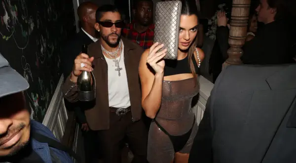 Kendall Jenner z torebką i Bad Bunny z butelką wina na imprezie.
