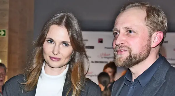 Piotr Adamczyk z żoną, uśmiechnięci, pozują do zdjęcia.