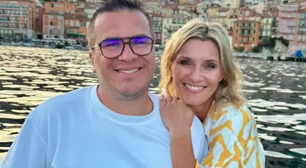 Anna Lewandowska i jej mąż cieszą się wakacjami nad wodą, w tle kolorowe kamienice.