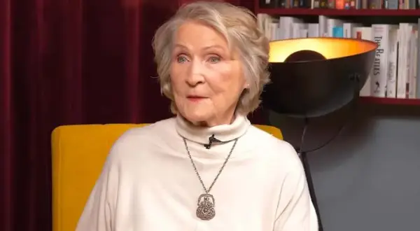 Irena Santor nie żyje. Ikona polskiej piosenki, w białym golfie i z naszyjnikiem, siedzi na żółtym fotelu.