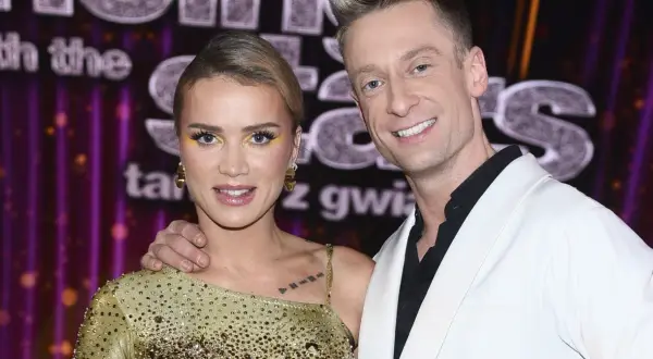 Maffashion i Danilczuk uśmiechają się do kamery. Ona w złotej sukience, on w białej marynarce.