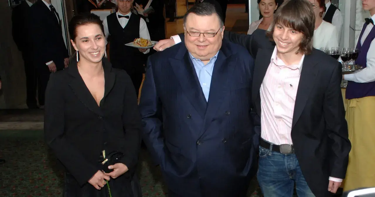 Wojciech Mann z córką i synem. Uśmiechnięci pozują do zdjęcia w eleganckich strojach.