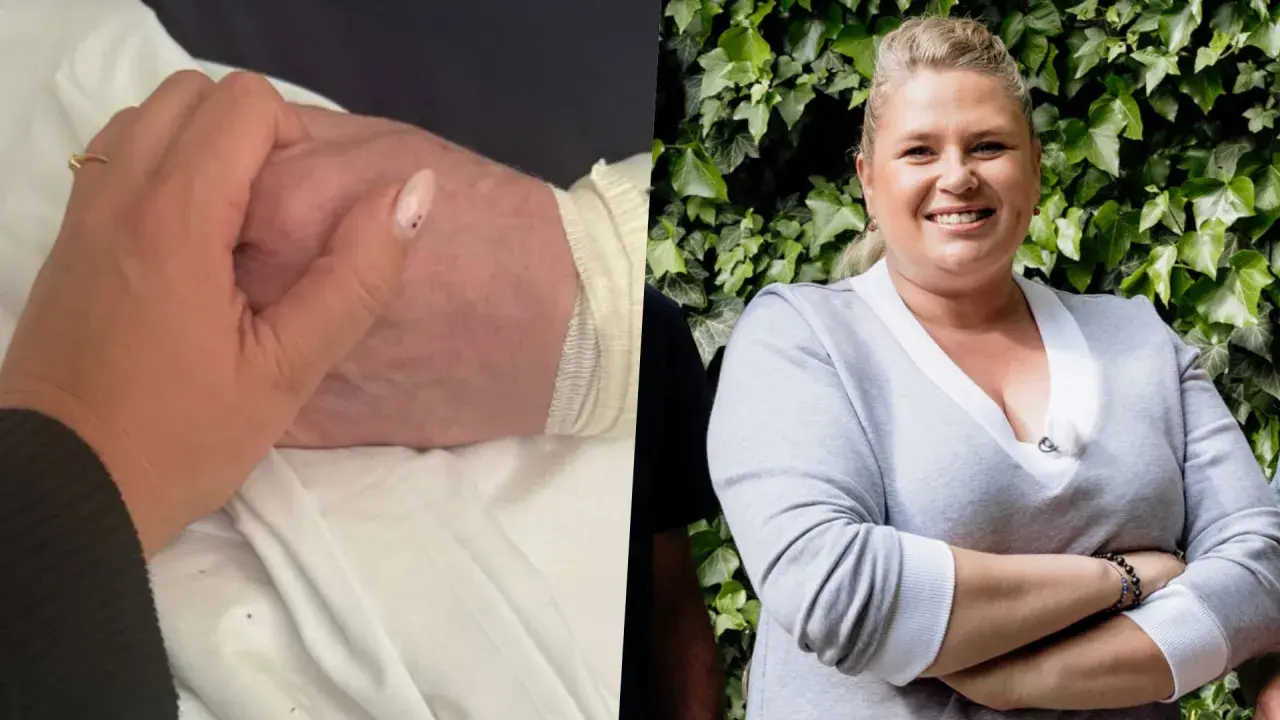 Elżbieta Romanowska trzyma za rękę bliską osobę, być może swojego męża, w trudnym momencie.