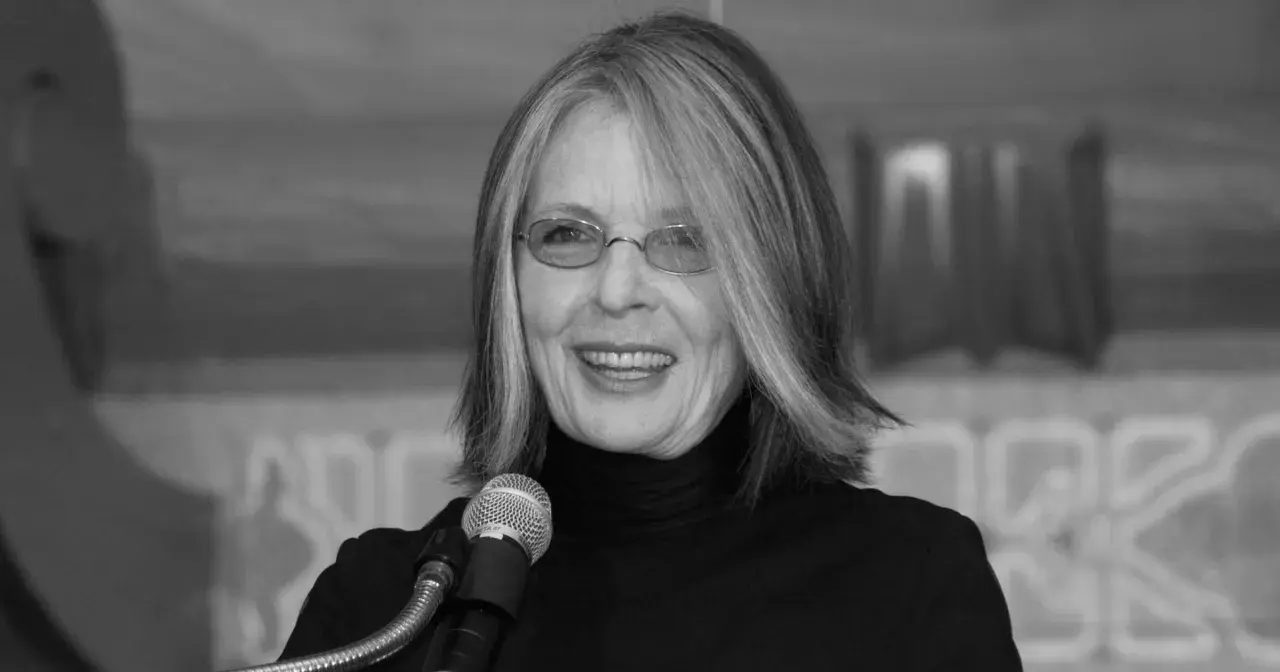 Diane Keaton w okularach i czarnym golfie, uśmiechnięta przy mikrofonie. Jej życie prywatne jest inspiracją dla wielu.