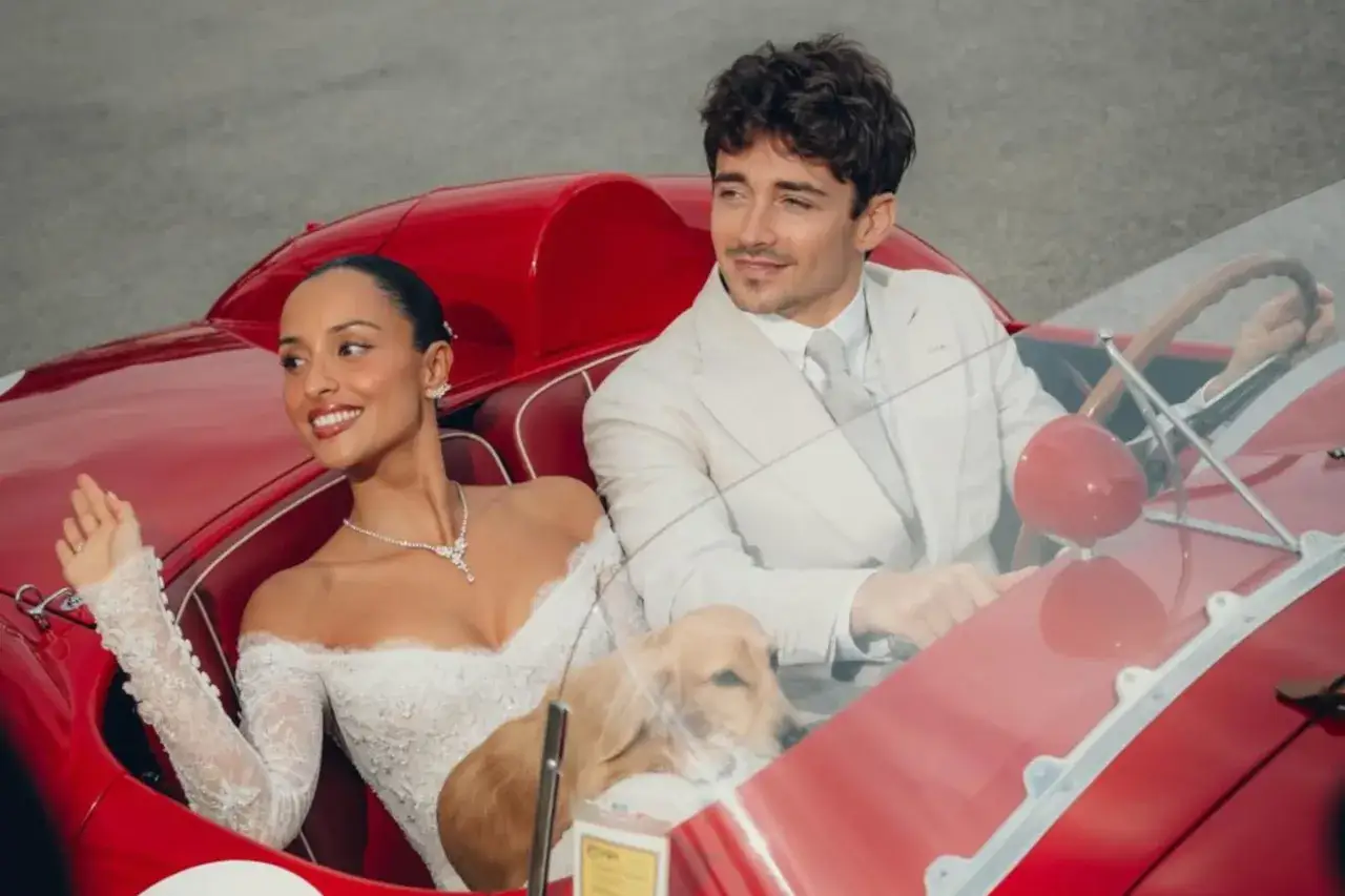 Charles Leclerc i jego dziewczyna w białych strojach, z pieskiem, w czerwonym kabriolecie.