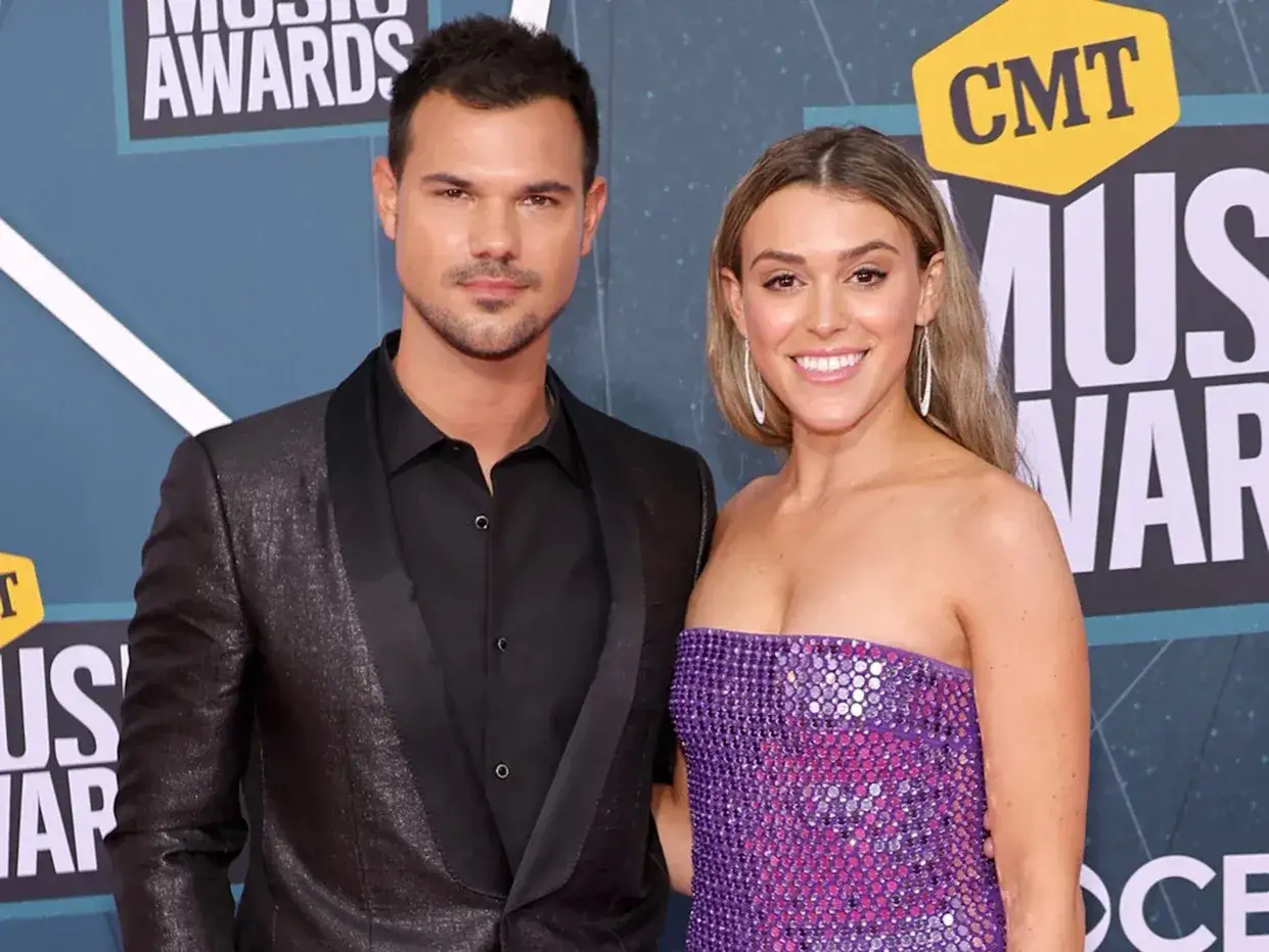 Taylor Lautner i jego żona na gali CMT Music Awards. Taylor w błyszczącym garniturze, ona w fioletowej sukni.