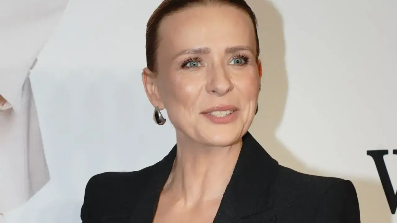 Aneta Zając w czarnej marynarce, z błyszczącymi kolczykami, wygląda promiennie.