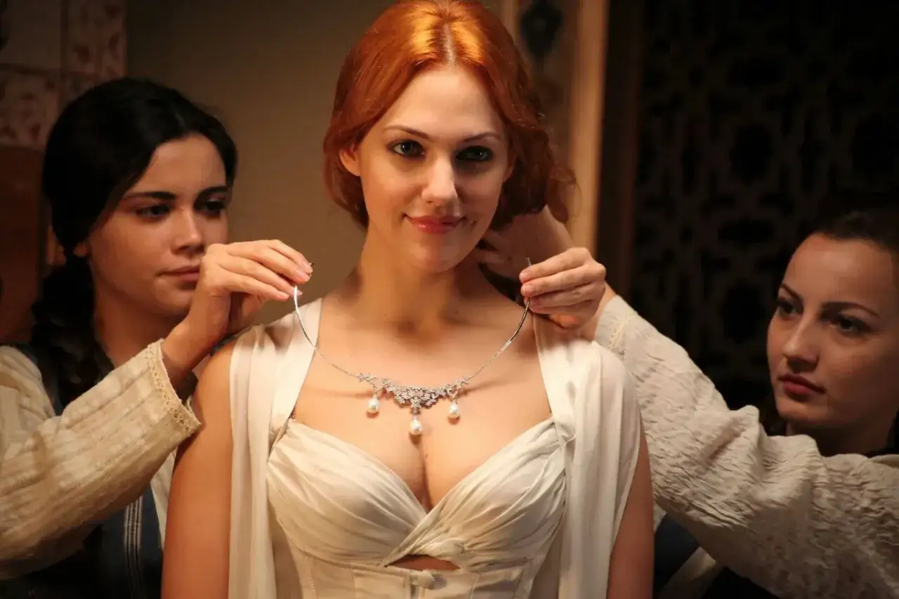 Meryem Uzerli, w białej sukni, otrzymuje naszyjnik od dwórek. Czy to prezent od jej męża?