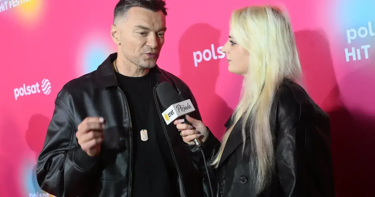 Artysta Liber udziela wywiadu na różowym tle z logo Polsat.