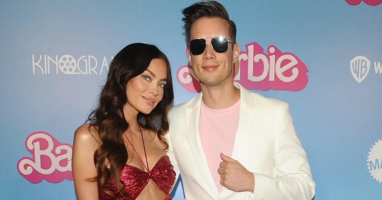 Edyta Zając i jej partner na premierze Barbie. Ona w błyszczącej czerwonej sukience, on w białej marynarce i różowej koszulce.