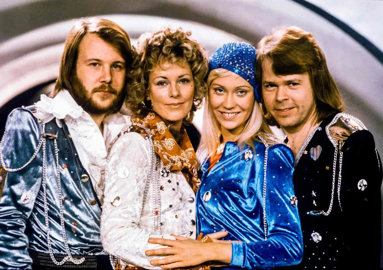Członkowie zespołu ABBA, w tym Agnetha, Björn, Benny i Anni-Frid, w swoich charakterystycznych strojach. Kto nie żyje? Wszyscy żyją!