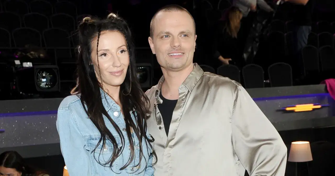 Marcin Hakiel z partnerką, wpatrzeni w obiektyw, pozują na tle widowni.
