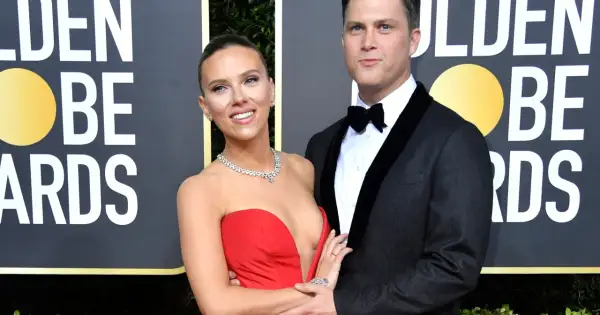 Scarlett Johansson w czerwonej sukni i Colin Jost w garniturze na ściance Golden Globe Awards.
