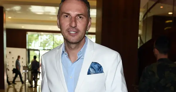 Krzysztof Gojdź w białej marynarce, z niebieską poszetką. Czyżby szykował się na spotkanie z żoną?