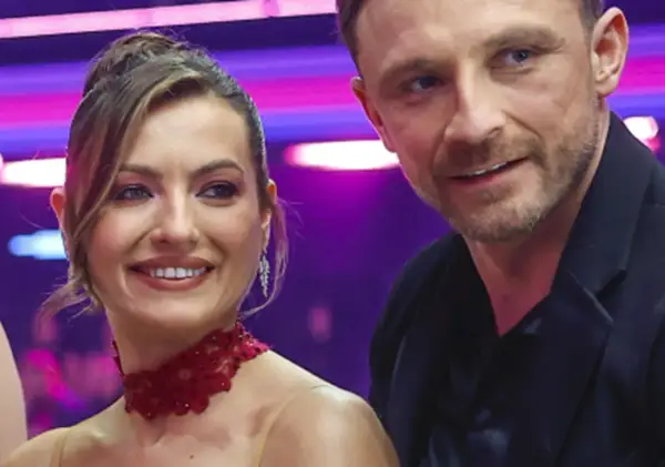 Kamil Nożyński z partnerką na scenie, uśmiechnięci i pełni energii.
