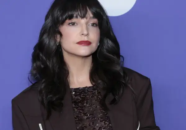 Maria Dębska, z partnerem u boku, prezentuje się elegancko w ciemnej marynarce i błyszczącej bluzce.