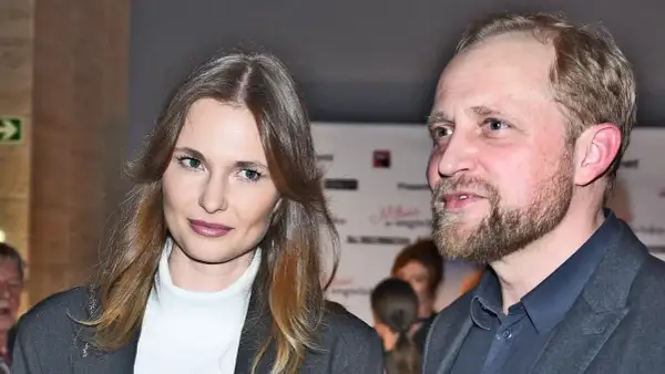 Piotr Adamczyk z żoną, uśmiechnięci, pozują do zdjęcia.