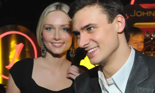 Patrycja Krogulska i jej nowy partner uśmiechają się do obiektywu. W tle neonowy napis.