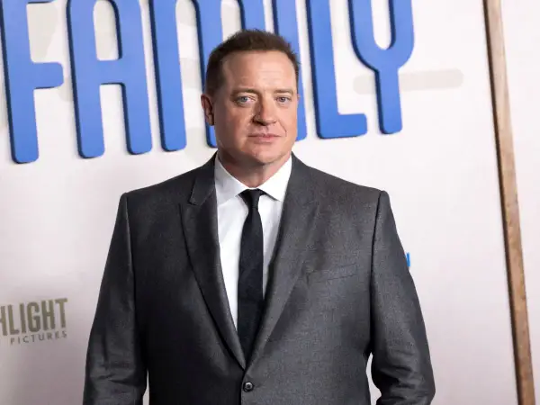 Brendan Fraser w garniturze, z widocznym napisem "FAMILY" w tle. Aktor pokonał chorobę i wrócił na czerwony dywan.