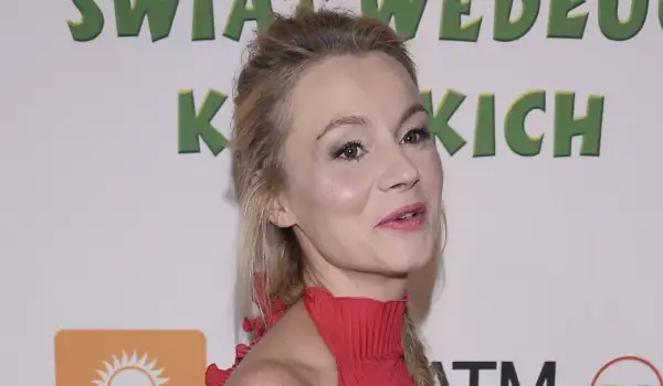 Anna Ilczuk, znana z ról filmowych, w czerwonej sukni. Jej mąż, jeśli jest obecny, pozostaje poza kadrem.