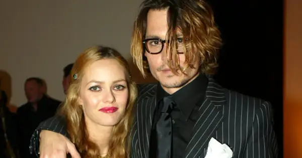 Johnny Depp i Vanessa Paradis na gali. Johnny w okularach i garniturze w paski, Vanessa z błyszczącymi ustami.